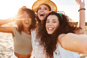 3 girlfriends smiling cheak to cheak on Madeira Beach